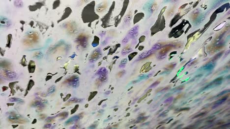 jabón de lavado de autos automático de colores del arco iris en la ventana, cera espumosa de cerca en cámara lenta