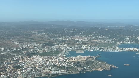 Aerial-view-of-Ibiza-city-and-harbor,-shot-from-an-airplane-cabin