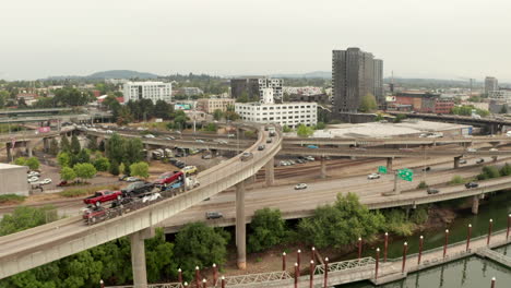 Aerial-shot-following-car-carrying-truck-over-a-highway-interchange