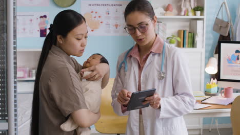 doctor examining a baby with its mother