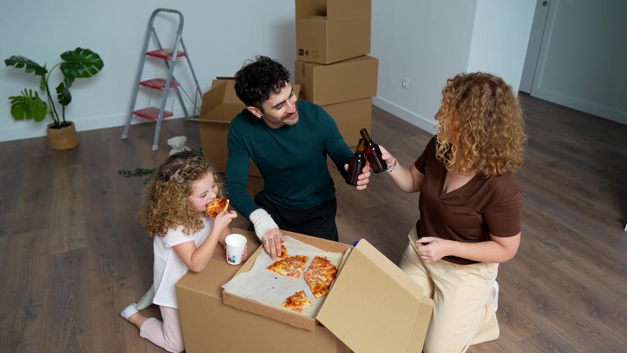 Family Eating Pizza on Floor in New Home