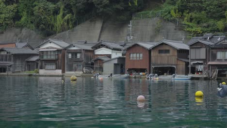 ripples in calm ocean waters with fisherman houses in the background