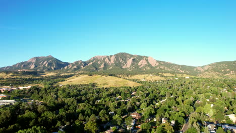 Slow-rising-Drone-shot-of-Boulder,-Colorado,-USA-on-a-summer-morning-with-the-flat-irons-in-the-background