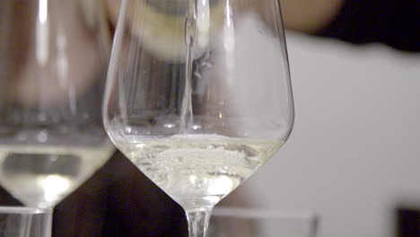 close-up of white wine being poured into a glass, highlighting the liquid’s flow and bubbles