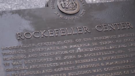 New-York-City-iconic-Rockefeller-Center-sign-slowly-getting-in-focus-in-slow-motion-during-daytime-on-fifth-avenue,-Manhattan