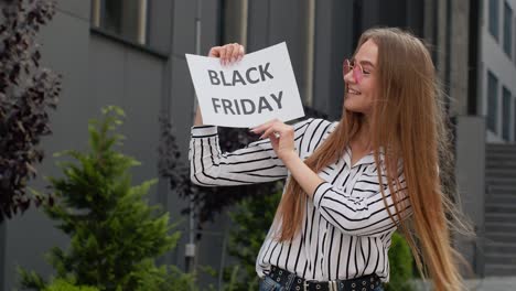 Mädchen-Hält-Die-Textaufschrift-„Black-Friday“-In-Der-Hand-Und-Freut-Sich-über-Gute-Rabatte-Und-Niedrige-Preise-Für-Online-Einkäufe