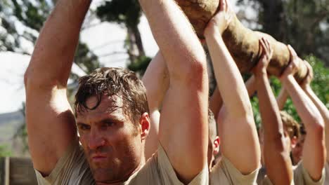 military troops carrying heavy wooden log during obstacle course 4k