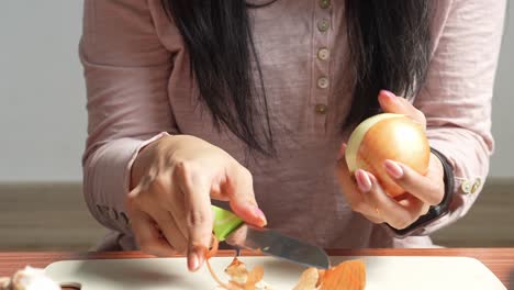 girl peeling onions with a knife