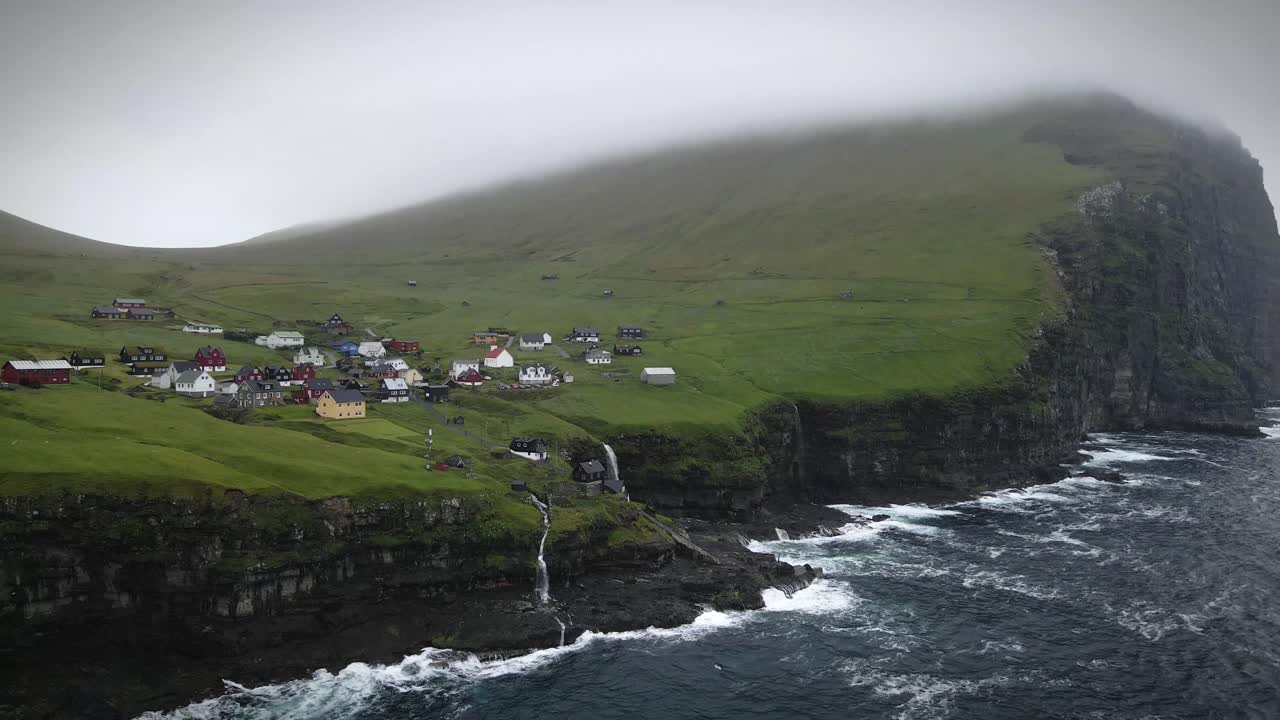 un pueblo pacífico en la isla de kalsoy con casas coloridas, acantilados escarpados, cascadas en cascada, y colinas verdes que se encuentran con el océano. un destino remoto que muestra paisajes nórdicos intactos y serenidad