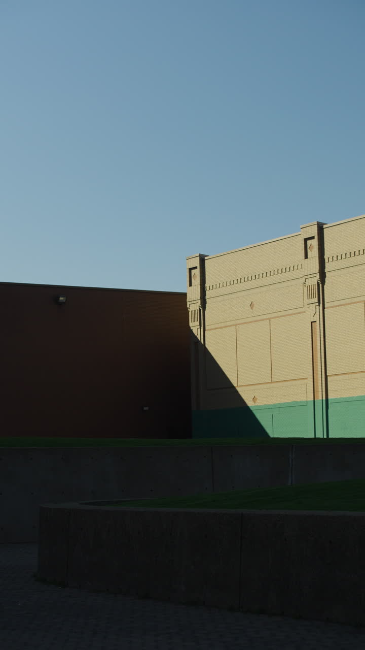 Vertical - Shadow Casted Against Painted Building Exterior Under Clear Blue Sky.