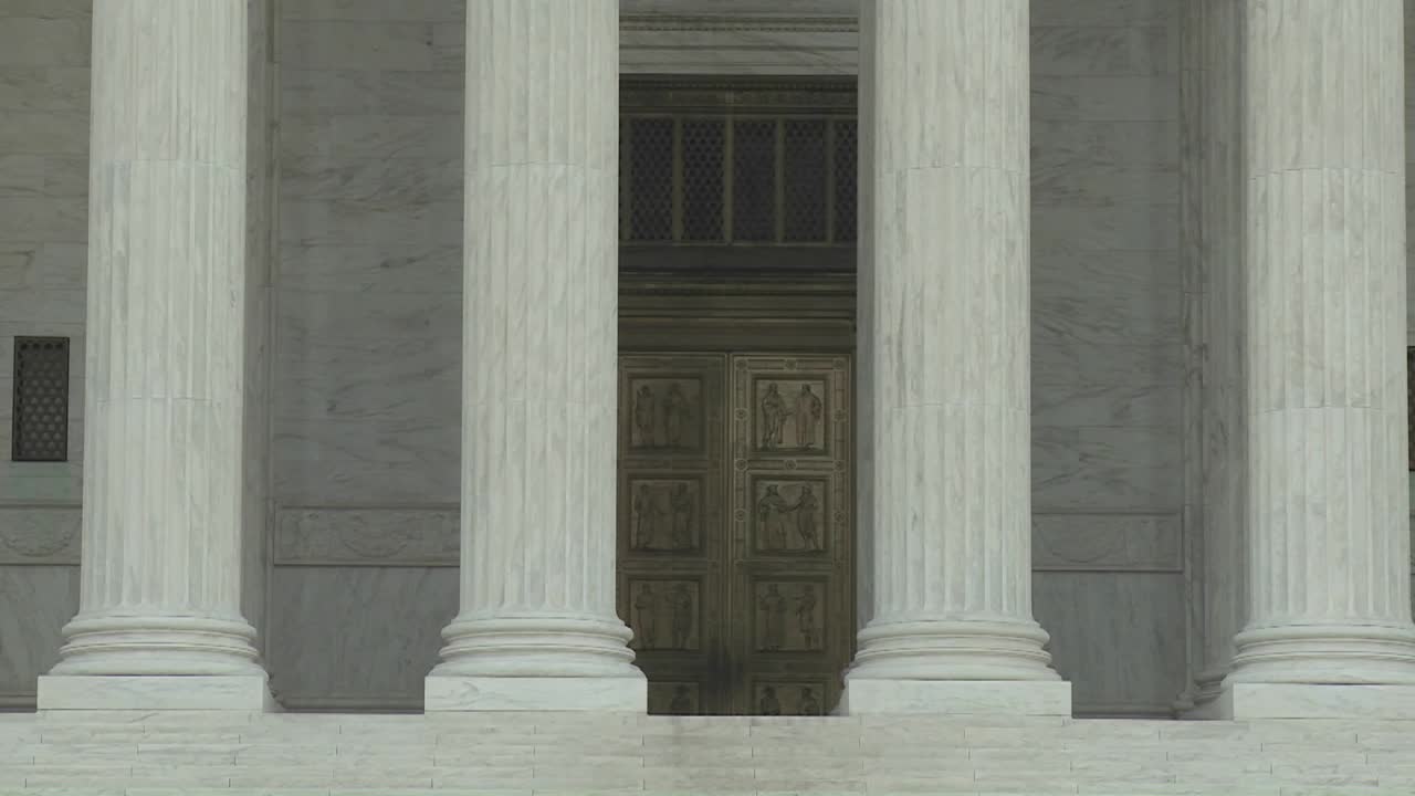 una inclinación hacia el edificio de la corte suprema y la frase igual justicia bajo la ley