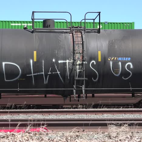 graffiti ateo en un vagón de tren con tanque de aceite dice que dios nos odia a todos