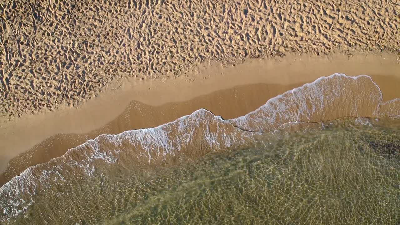 해변의 모래사장을 때리는 파도의 조감도