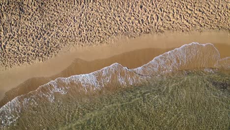 Vista-Aérea-De-Las-Olas-Golpeando-La-Orilla-Arenosa-De-La-Playa