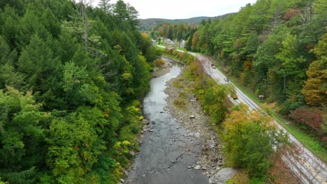 Aerial-drone-videography-of-cars-traveling-on-a-riverside-street