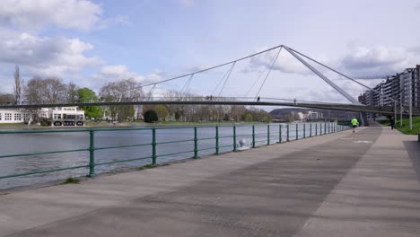 person running alongside the river meuse on a sunny day