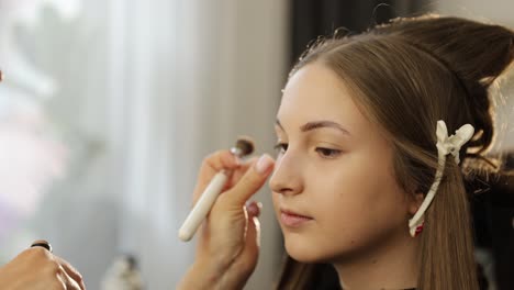 close-up of attractive young woman receiving beauty procedure in spa salon. pampering concept. ultrasound treatment on forehead. beautician making face massage