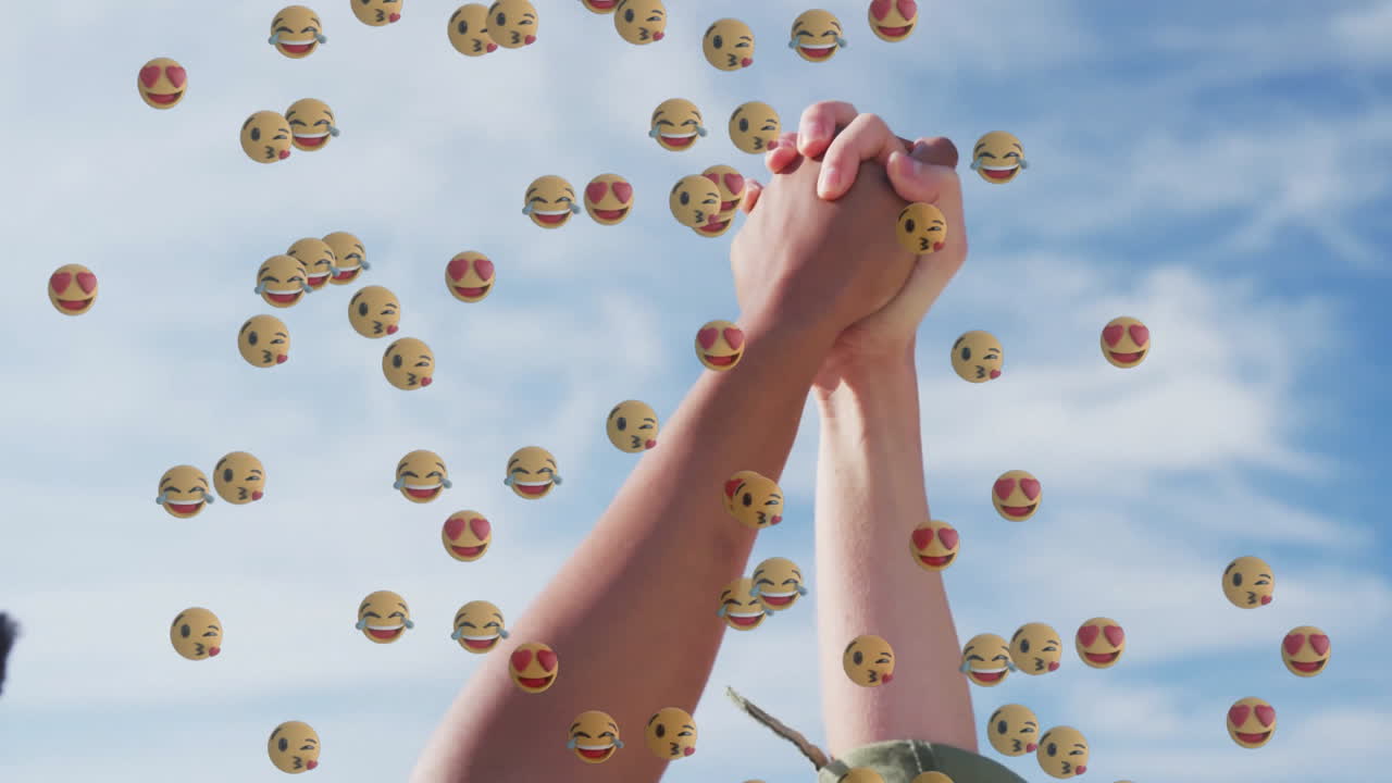 Two women raising joined hands featuring floating heart eyes laughing tears kissing emojis for ads