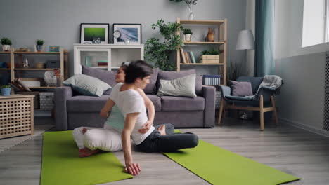 couple practicing partner yoga at home