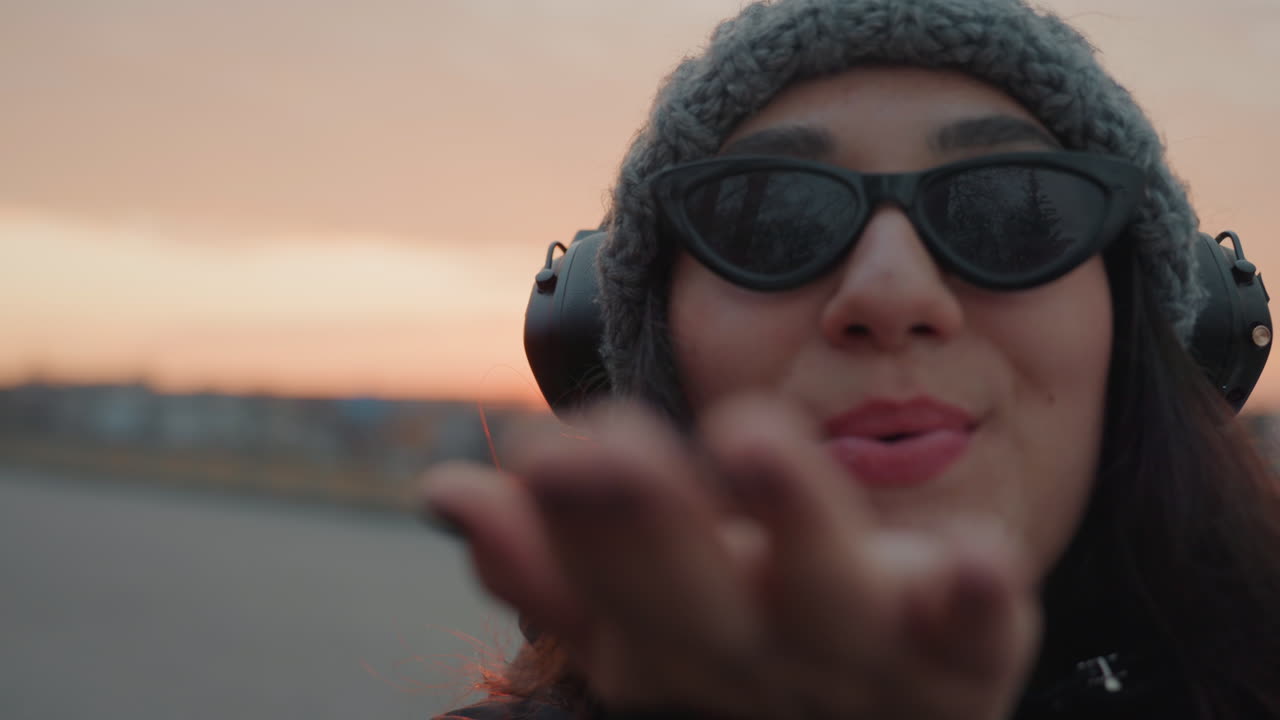 Donna felice sorride. Scatto intimo di una donna che manda un bacio civettuolo. Donna con un sorriso smagliante e un gesto giocoso vicino alla fotocamera. Immagine ravvicinata di una donna gioiosa che manda un bacio giocosamente verso l'obiettivo.