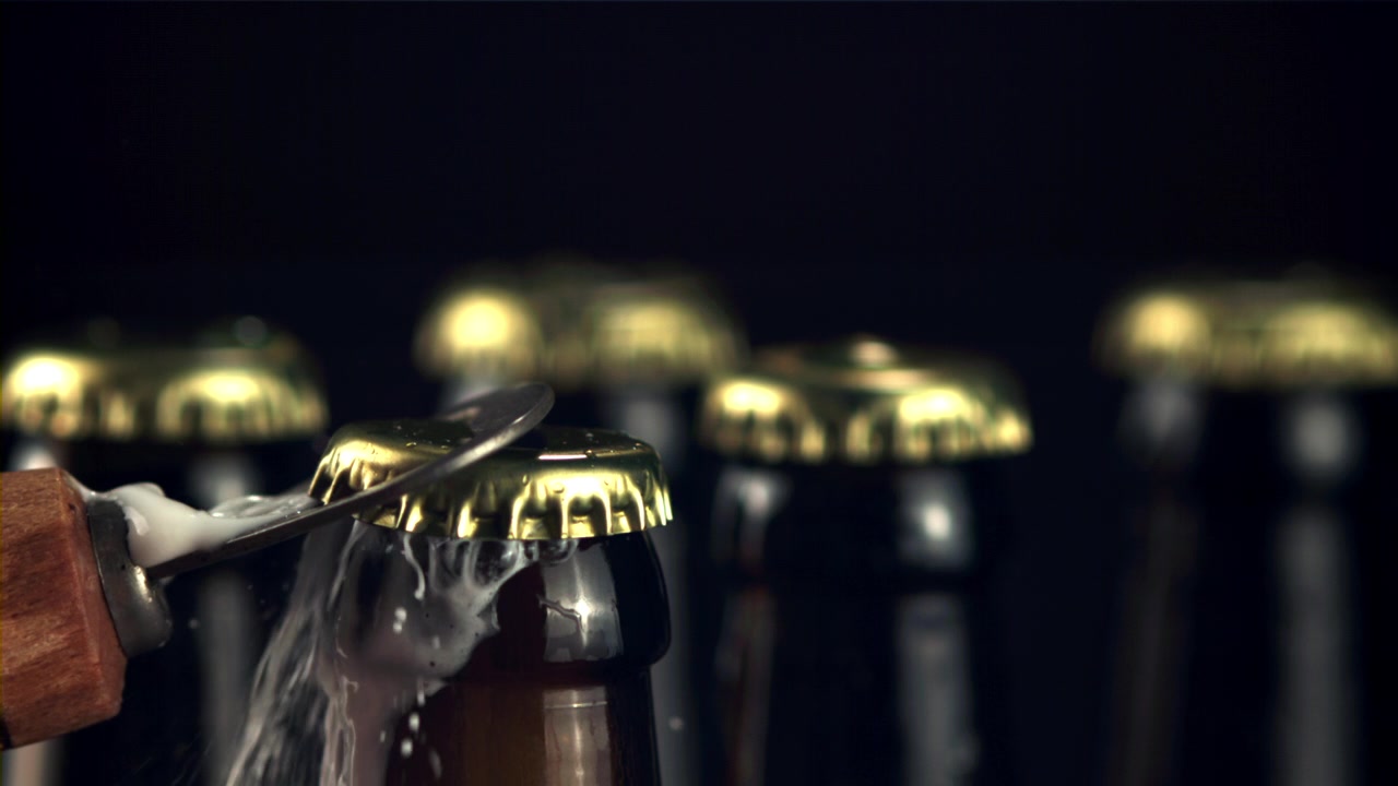 Zeitlupen-Nahaufnahme einer sich öffnenden Bierflasche mit Schaum
