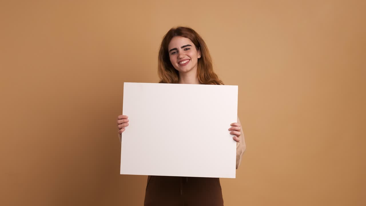 Happy young woman gesturing at white blank sheet