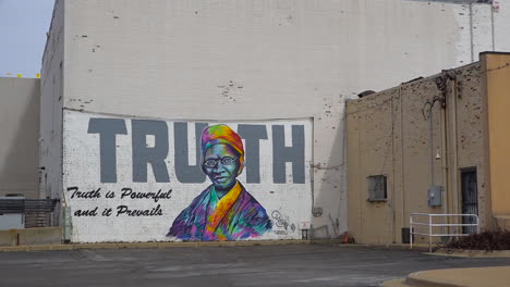 um mural diz a verdade em uma parede sob um prédio alto no centro da cidade em battle creek michigan 1