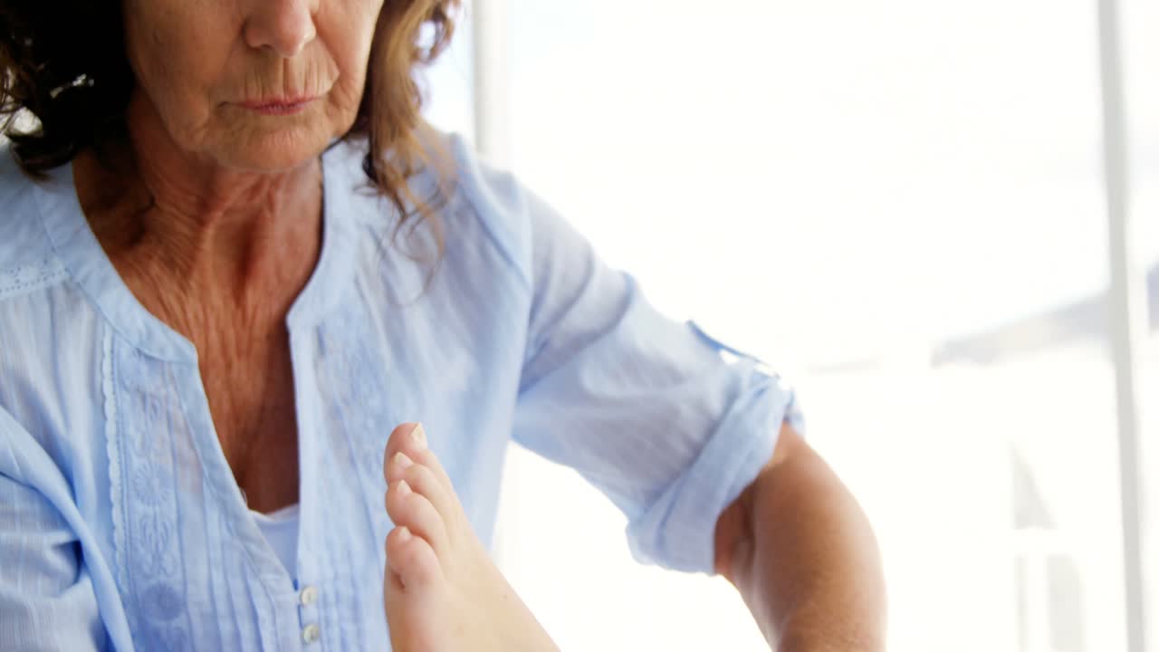 여성 치료사 가 환자 의 발 을 마사지 하고 있다