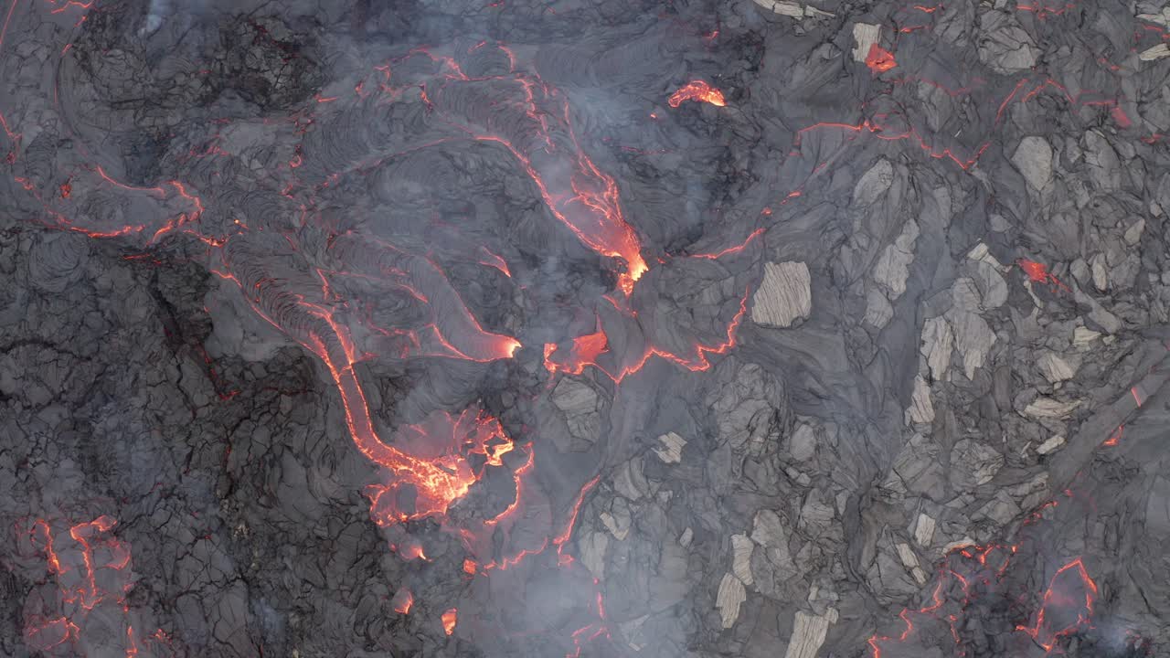 Lava incandescente e fumante che scorre nel terreno crepato durante l'eruzione vulcanica di Fagradalsfjall nella penisola di Reykjanes, Islanda del Sud.