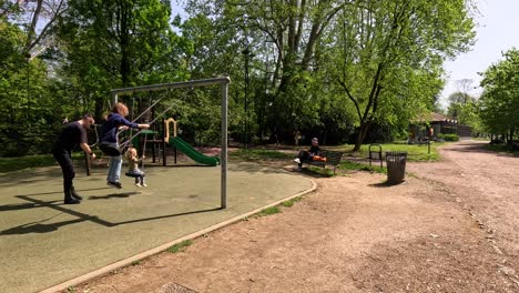 child on swing pushed by adult