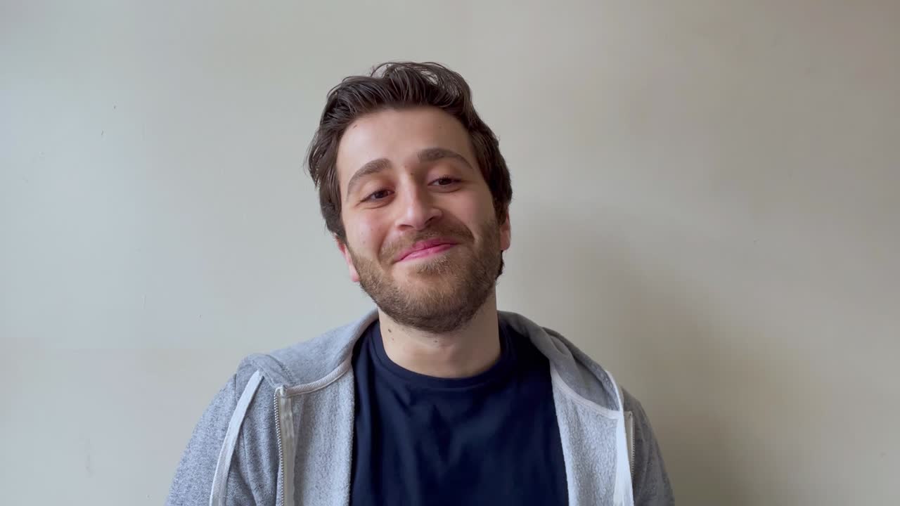 온라인 비디오 강의 중 웃음을 참으려는 젊은 남자 대학생