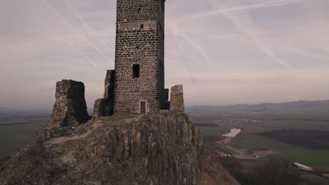 tilting up drone view revealing medieval hazmburk castle hilltop tower ruin