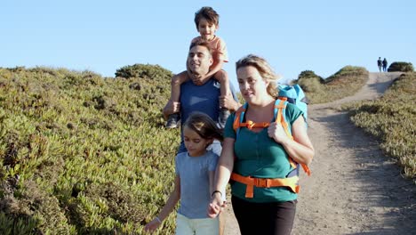 couple of active parents and children walking on path