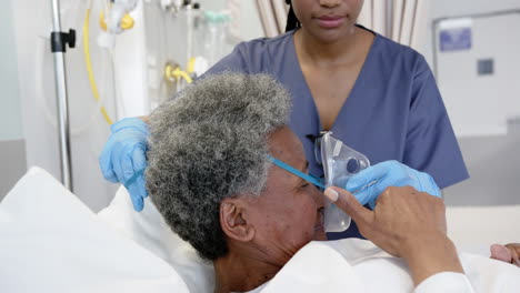 Doctora-Afroamericana-Aplicando-Máscara-De-Oxígeno-A-Una-Mujer-Mayor-En-La-Habitación-Del-Hospital,-En-Cámara-Lenta