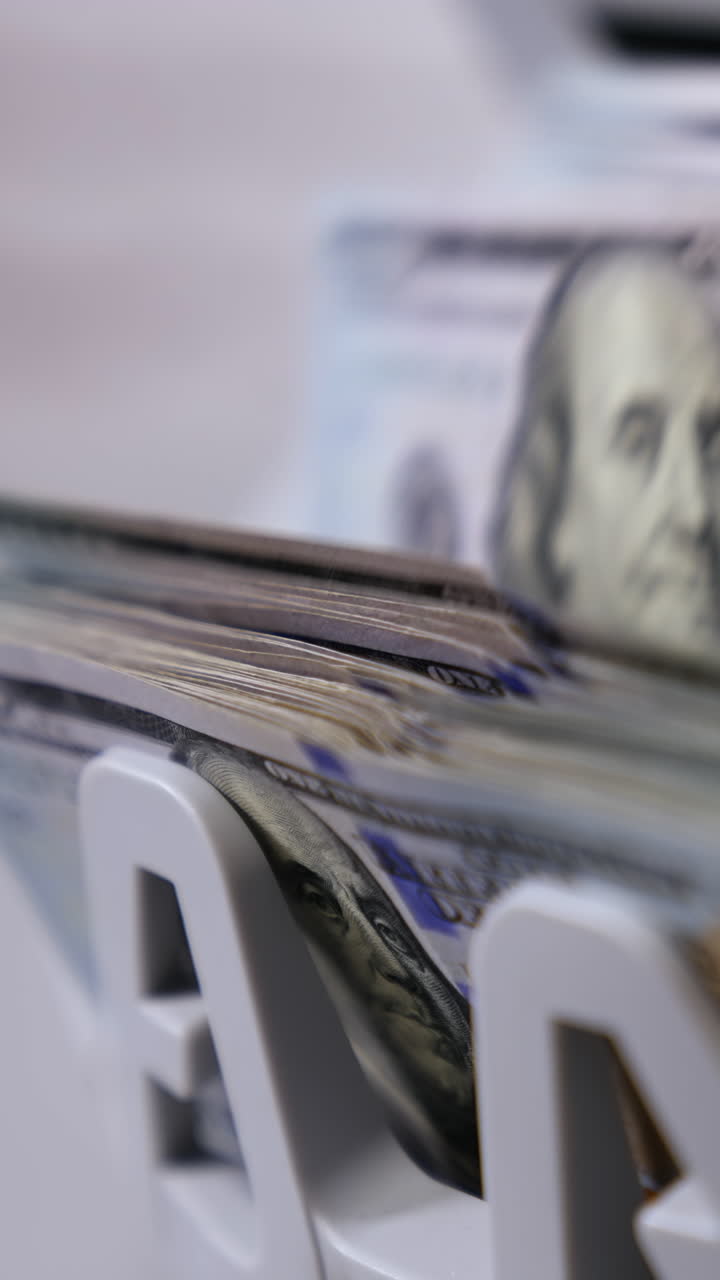 Money counting machine. Banknote counter are counting hundred dollar bills. Close-up Vertical video