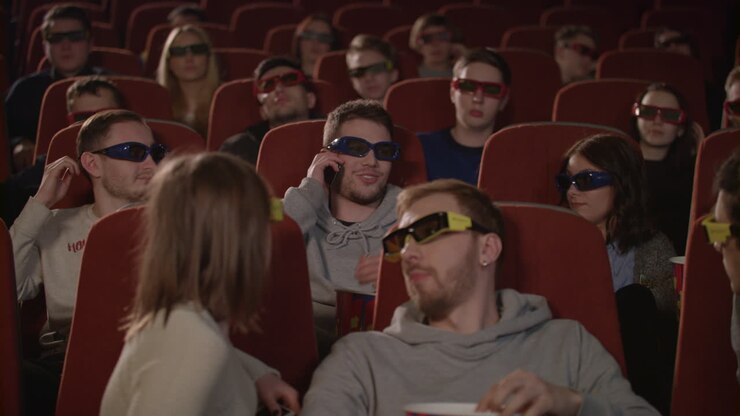 Uomo che parla al telefono nella sala del cinema