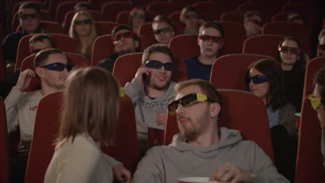 Man-talking-on-phone-in-the-cinema-hall