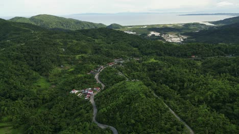 stunning orbiting aerial view of rural hillside village amid lush tropical island greenery at buenavista, catanduanes, philippines