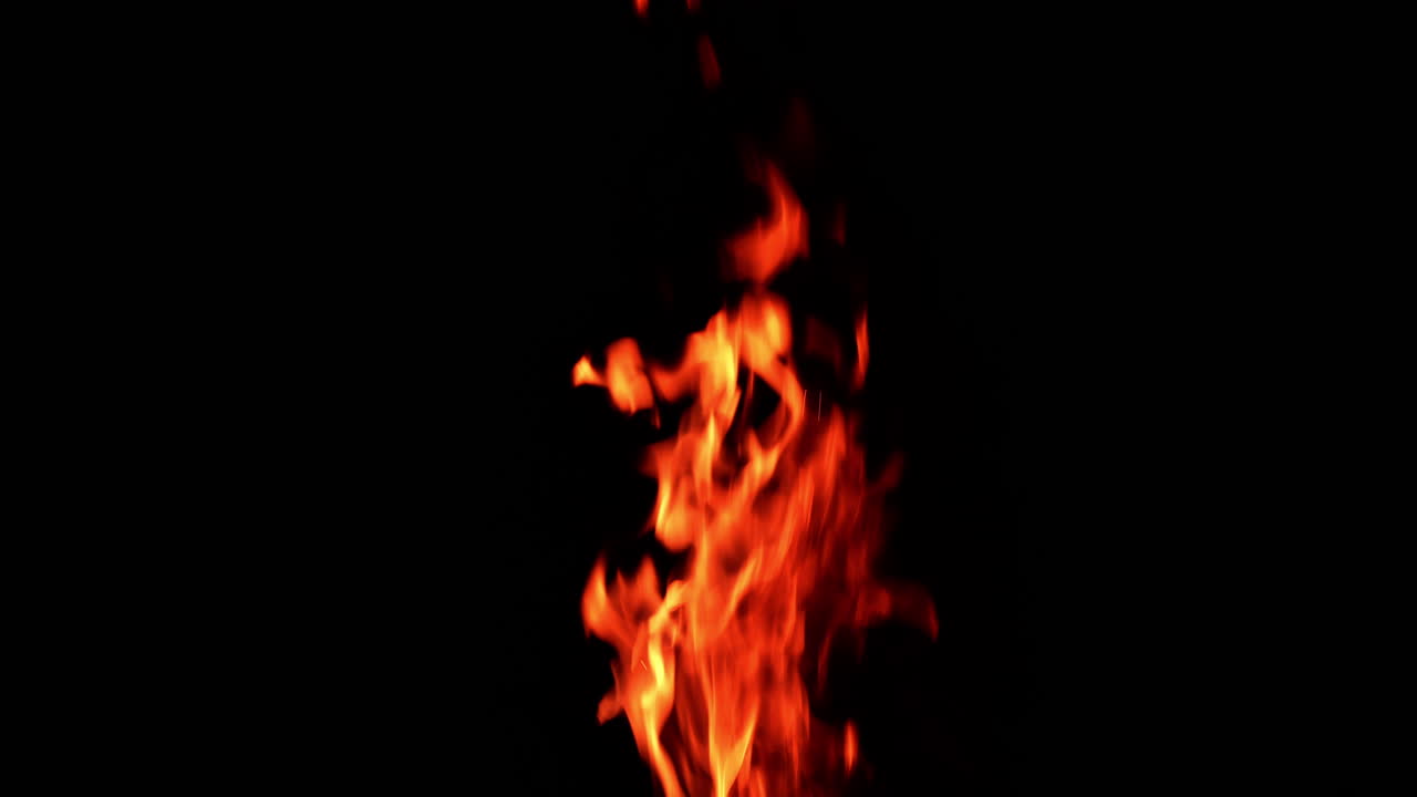 Flame of fire rising up in the darkness. Tongues of flames from bonfire isolated.