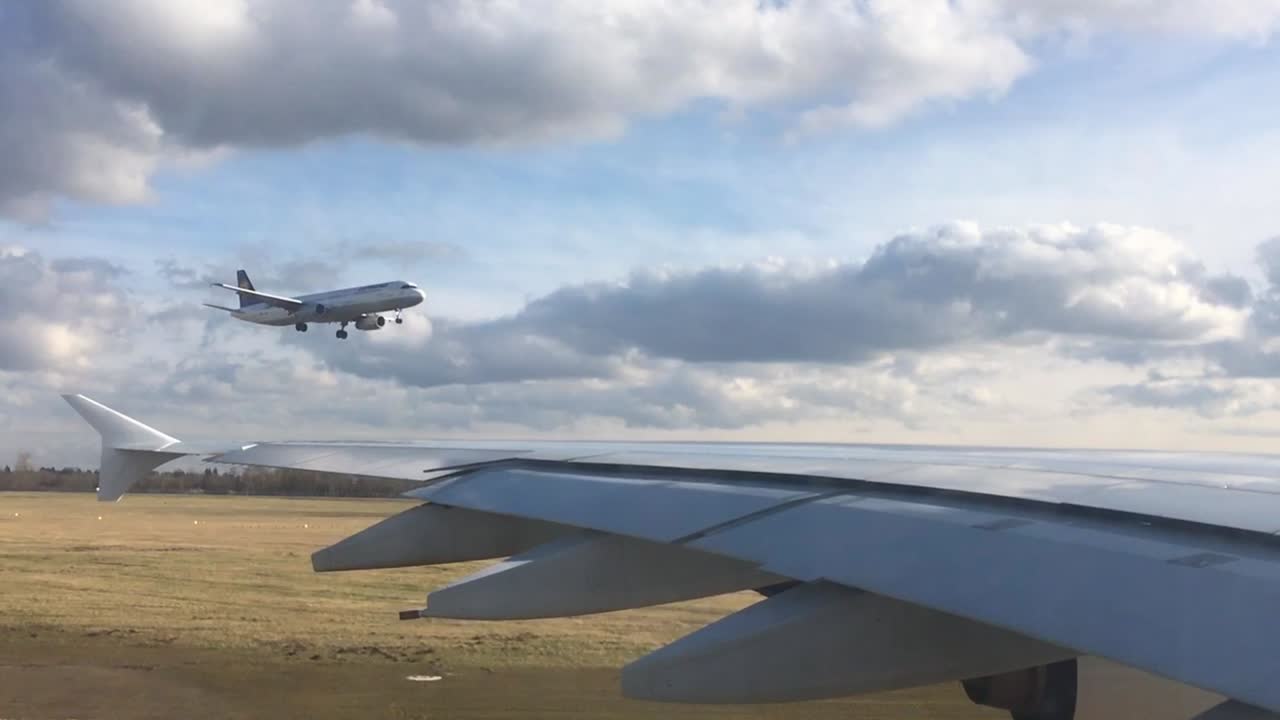 Final approach to landing of a Passenger Airplane filmed from another plane's window