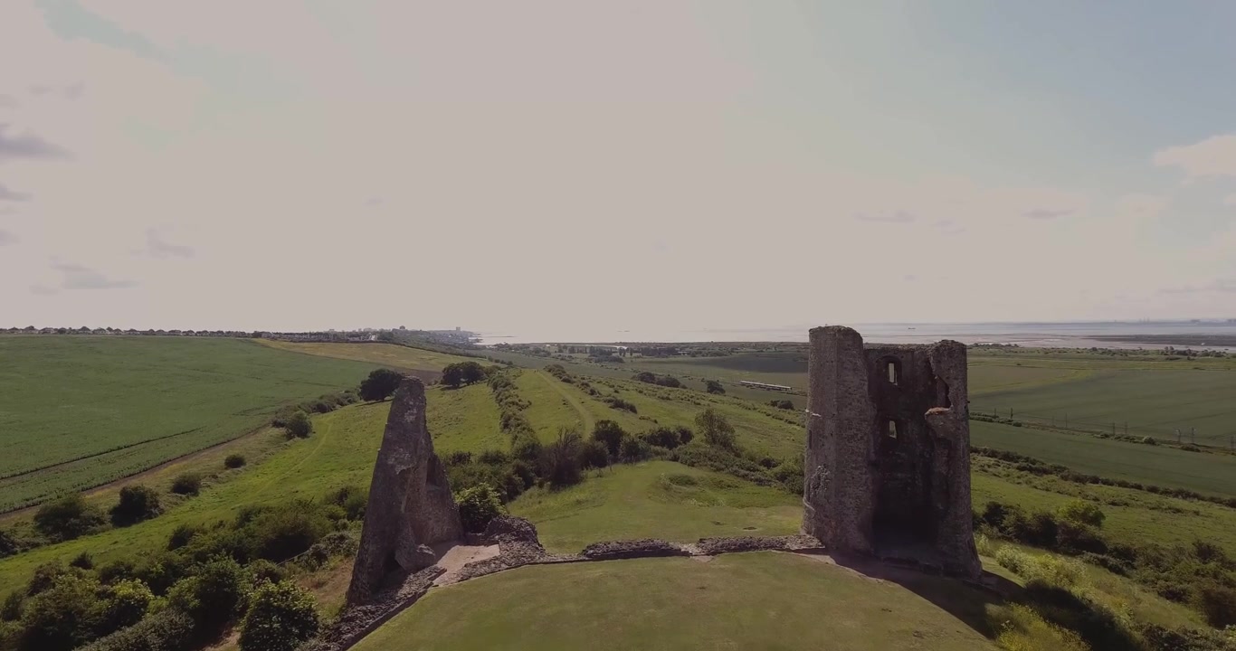 Hadleigh Castle i Essex. Drönarvy (4K DJI Phantom) med låg inflygning mot huvudtornet. Ett tåg är i bakgrunden, kameran passerar tornet och följer tåget.