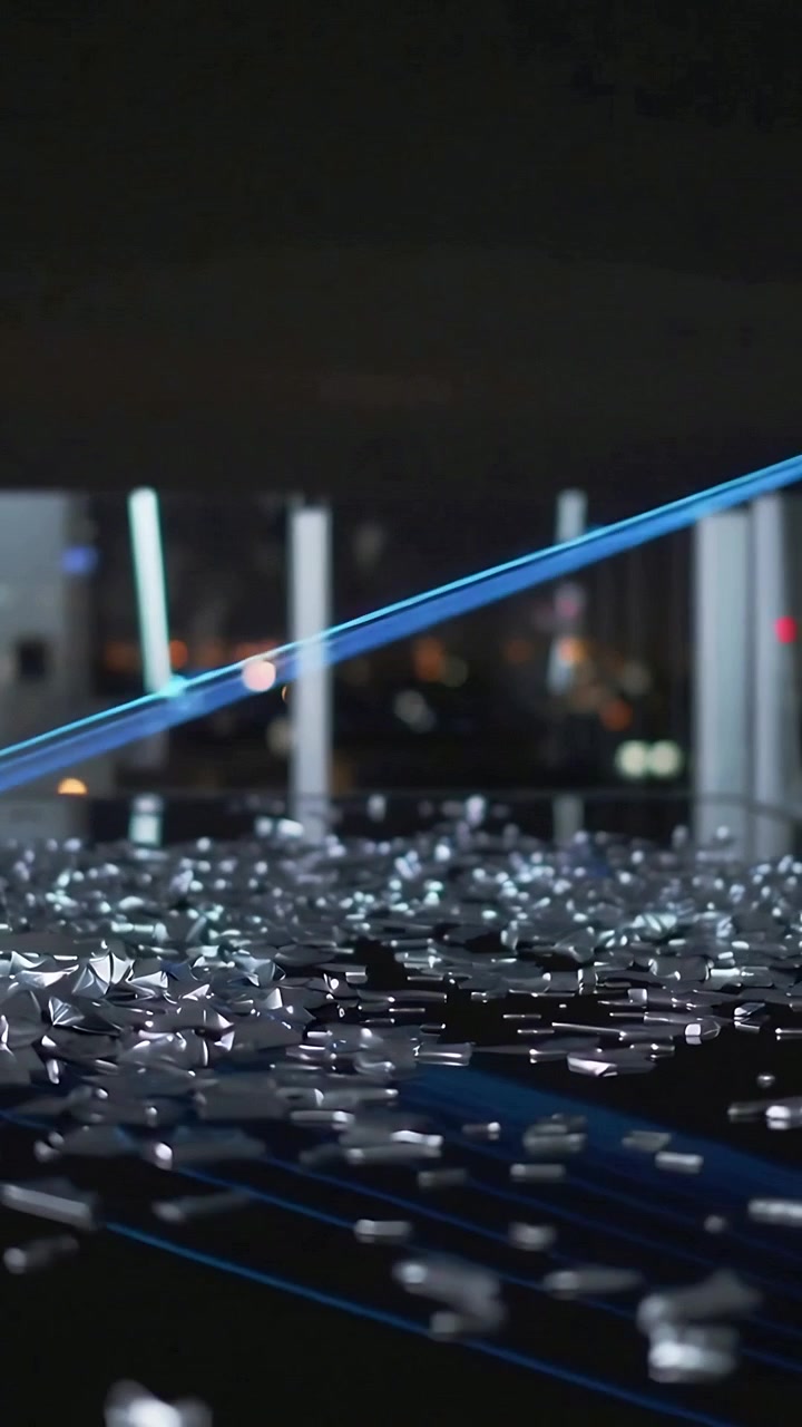 Vertical video: Appearing blue point firing beams raking metal bits on floor by glass making glints