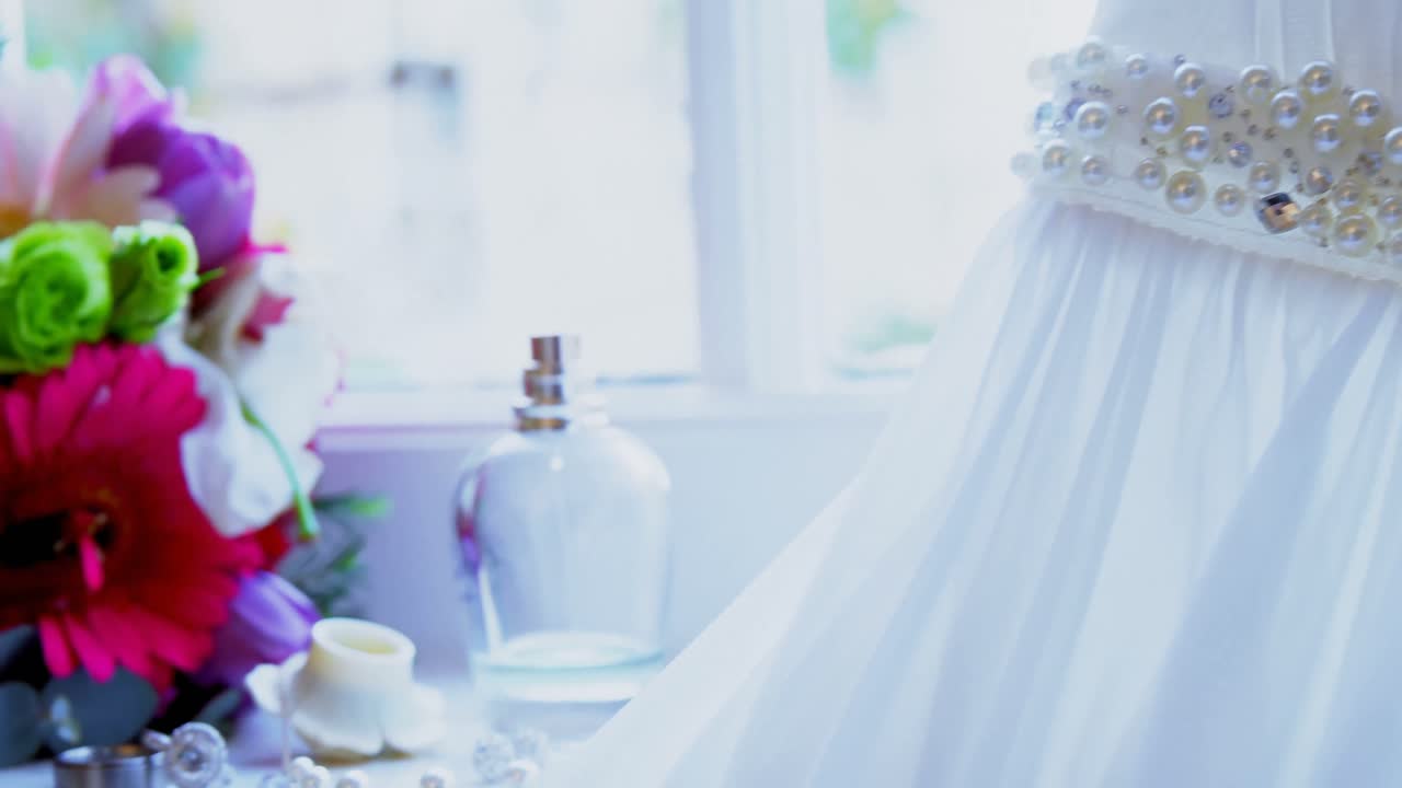 Wedding dress along with wedding rings and flowers 4K 4k