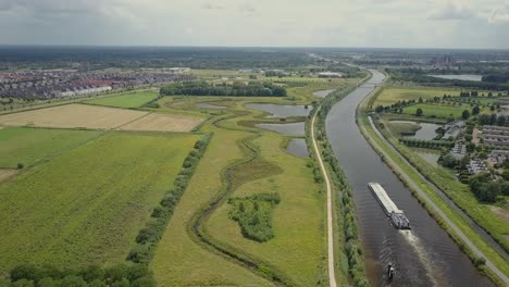 Luftdrohnenansicht-Der-Epischen-Szene-Am-Kanal-Und-Dem-Versandboot,-Das-In-Den-Niederlanden,-Europa-Vorbeifährt