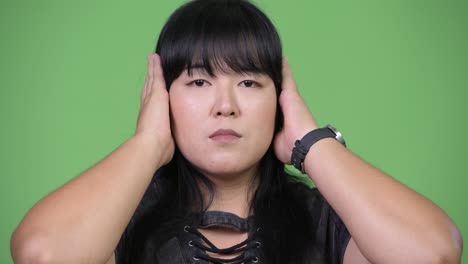 beautiful overweight asian woman covering ears as three wise monkeys concept