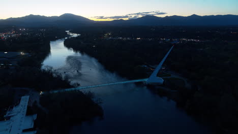 Imágenes-Aéreas-Girando-Alrededor-Del-Puente-Del-Reloj-De-Sol-Al-Atardecer-Sobre-El-Río-Sacramento-En-Redding,-California.