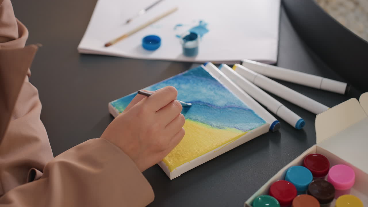 섬세한 붓질로 해변 그림을 돋보이게 하고, 숙련된 손길로 정교한 해양 예술 작품을 만들며, 집중한 아티스트가 해양 장면의 미니어처 팔레트에서 섬세한 붓 기술을 능숙하게 사용합니다.