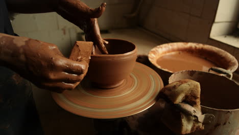 artist sculpting from wet clay in studio. master making clay pot in workshop