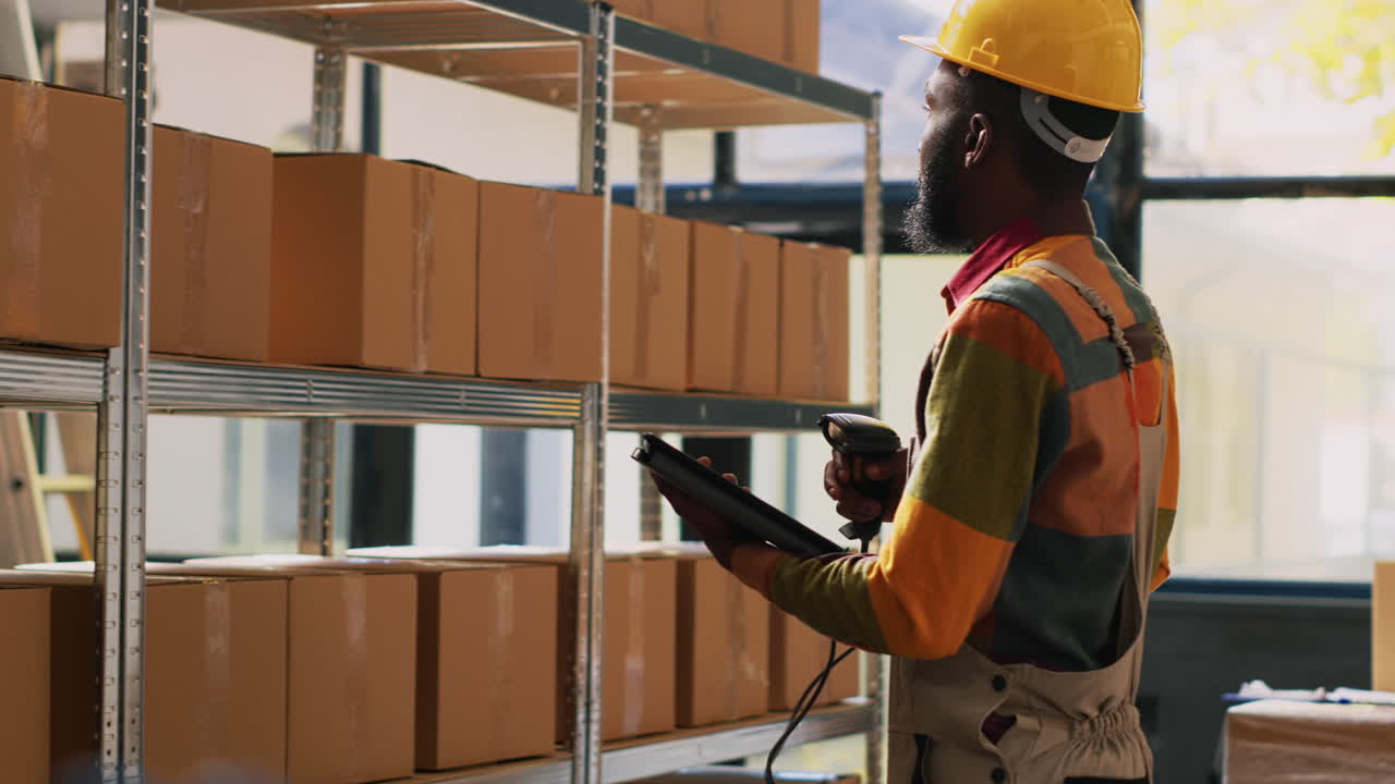 Warehouse worker scanning packages in storage with barcode scanner and tablet