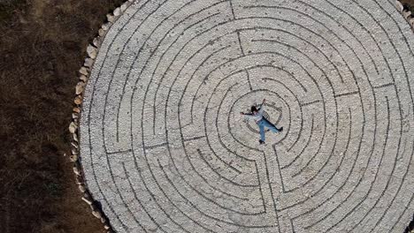 Vista-Aérea-De-Un-Niño-Tendido-En-Medio-De-Los-Círculos-De-Mosaico-De-Avdimou